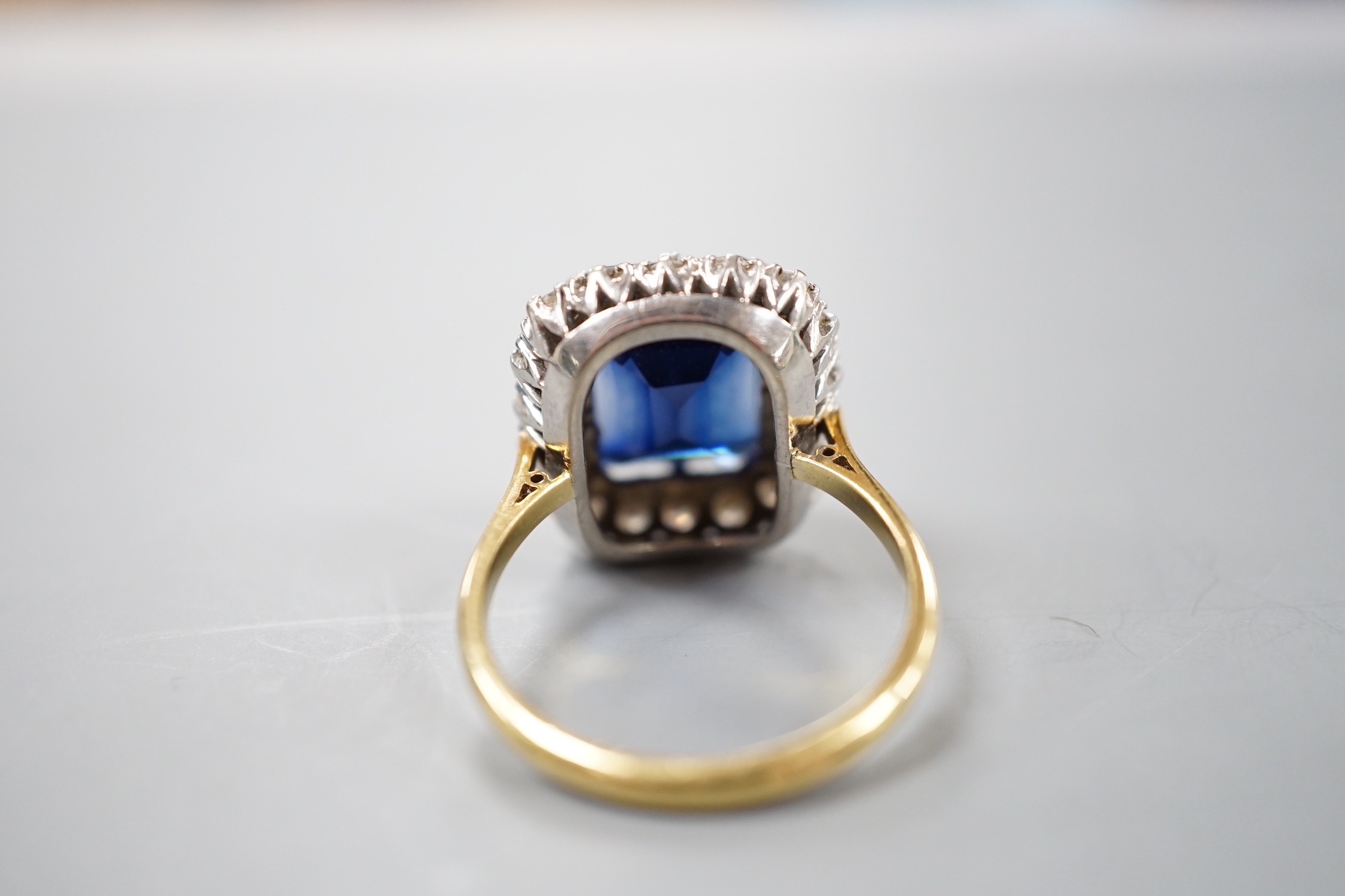 An 18ct, synthetic sapphire and diamond set rectangular cluster dress ring, size T/U, gross weight 10 grams.